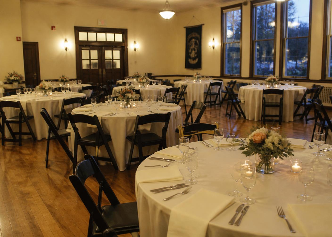 The Le Radici clubhouse hall set with round tables for a private event